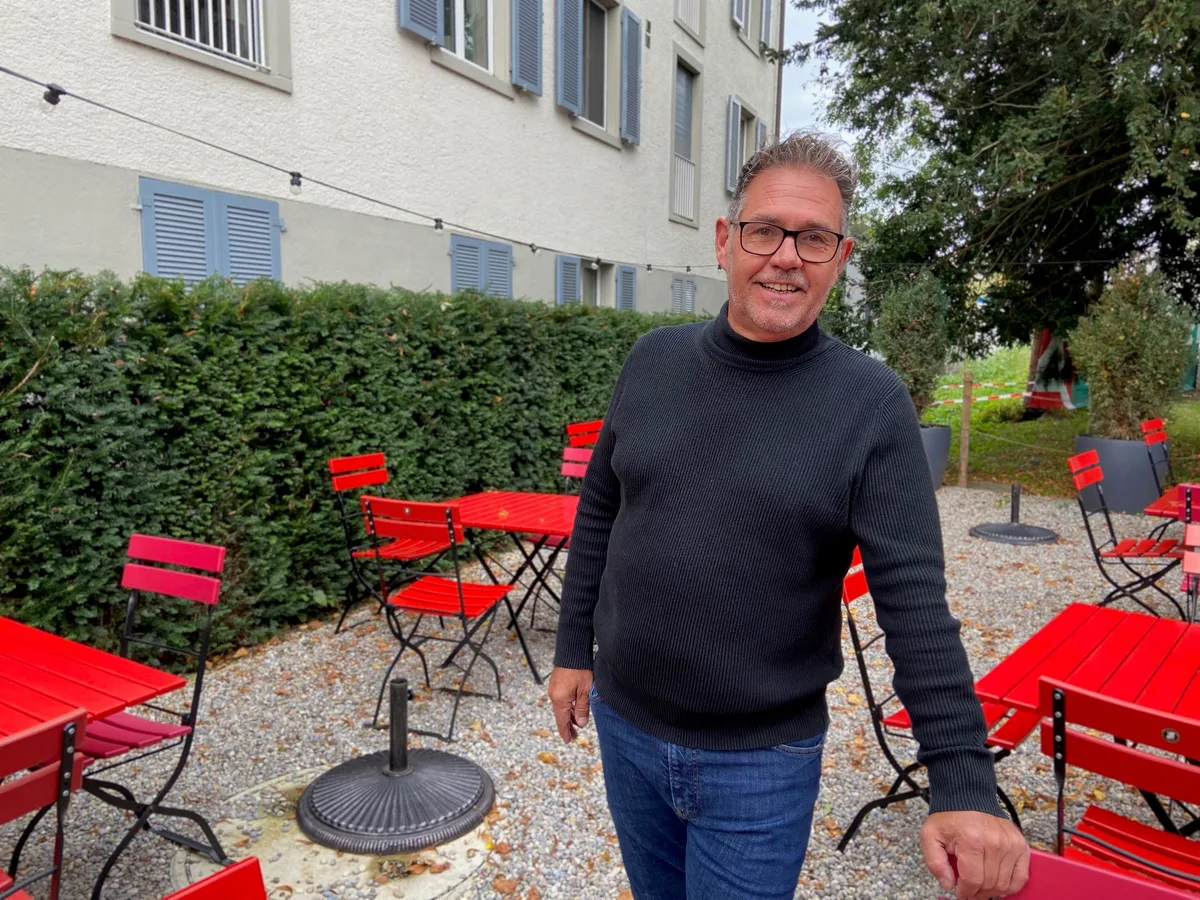 Markus Blaser steht auf seinem Kiesvorplatz und stützt sich auf einen Gartenstuhl. 